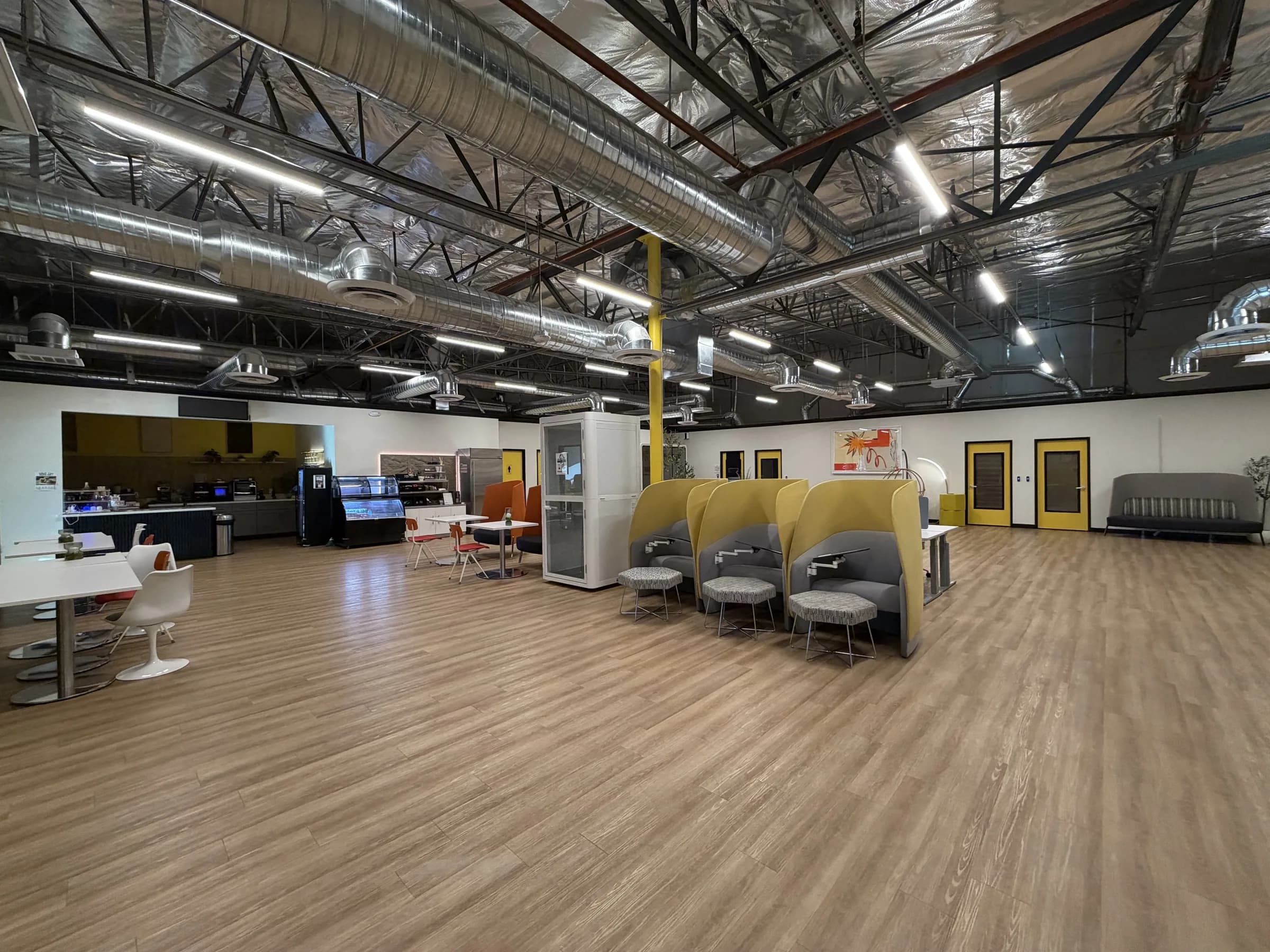 Coworking lounge with communal tables, private booths, and cafe seating in Las Vegas