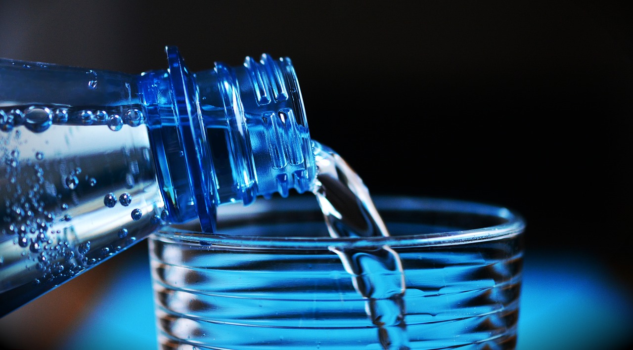 Someone pouring a glass of water