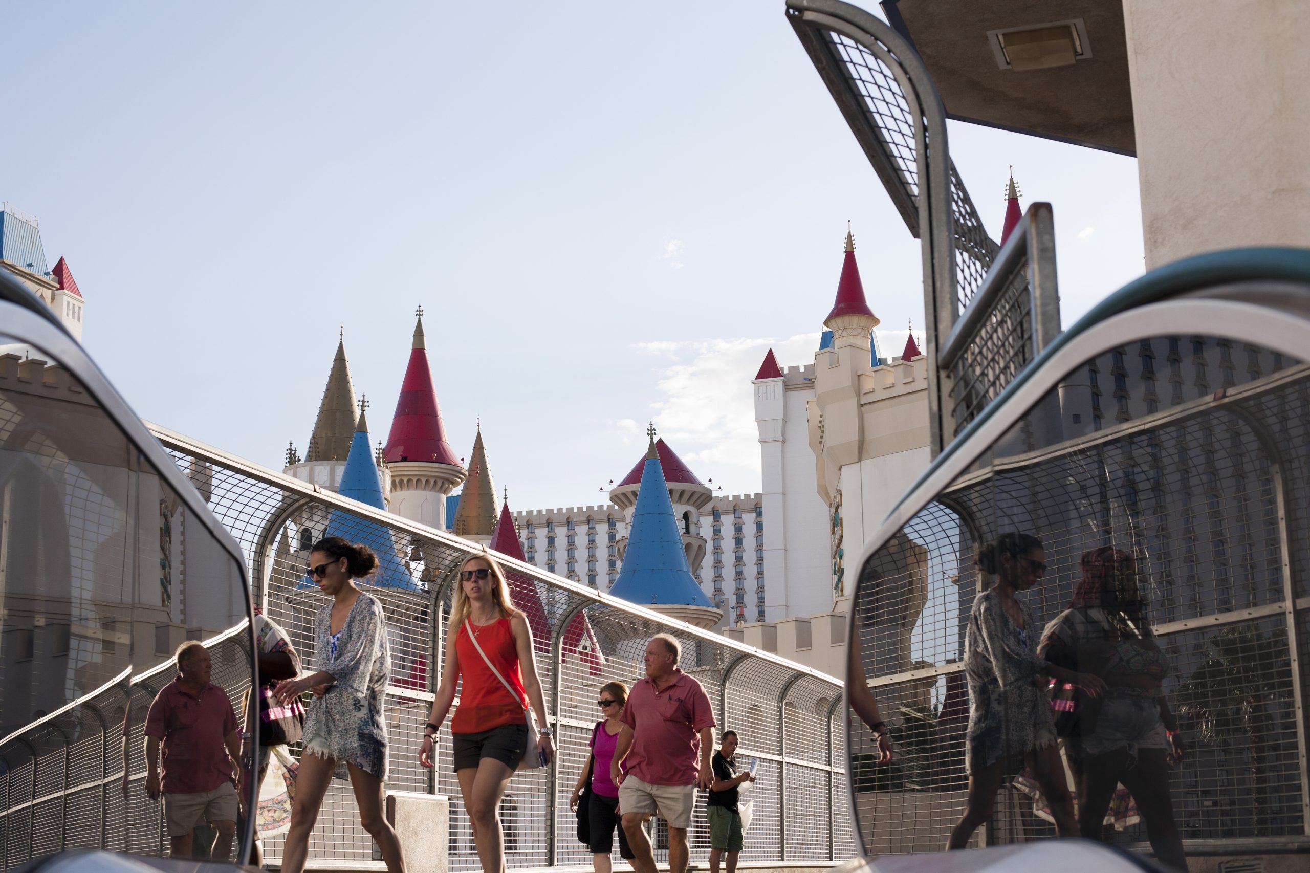 Tourists strolling on a sunny day with iconic castle architecture in Las Vegas